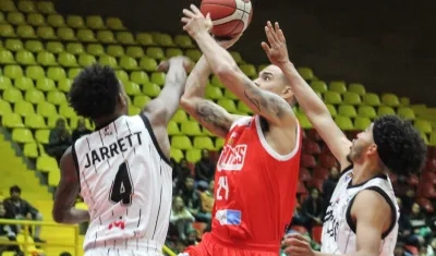 Jonathan Rodríguez intenta lanzar ante la marca de dos jugadores de Piratas. 