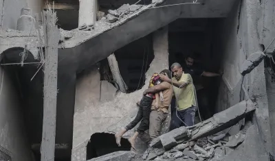  Un niño es rescatado de los escombros de un edificio residencial derribado.