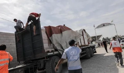 Funcionarios de la Media Luna Roja palestina ayudan a descargar la ayuda para la Franja de Gaza