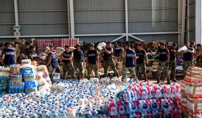 Personal de la Marina empaqueta y traslada despensas a una zona afectada tras el paso del huracán Otis. 