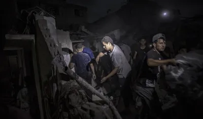 Palestinos buscan cadáveres y supervivientes tras un ataque israelí en Jan Yunis, sur de la Franja de Gaza.