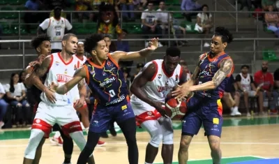 Juan Diego Tello en poder de la pelota en medio de dos rivales. 