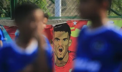 Jóvenes de escuela de fútbol entrenan en Barrancas y al fondo una retrato de Luis Díaz. 