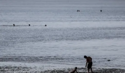Un hombre y un niño se bañan en el Río de la Plata, en una fotografía de archivo