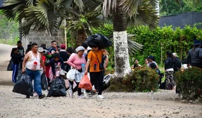 Migrantes cargando sus pertenencias en la entrada a la selva del Darién.