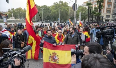 Varias personas con banderas de España protestan en las inmediaciones del Congreso de los Diputados