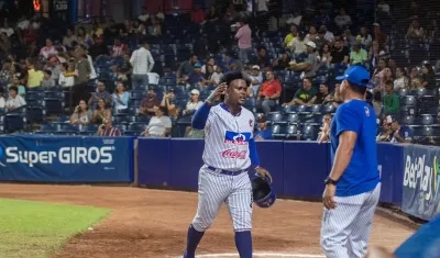 Dilson Herrera es felicitado por su mánager José Mosquera tras batear un jonrón de tres carreras en el segundo juego. 