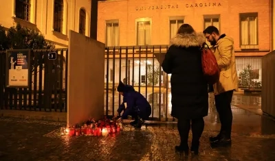 Habitantes de Praga ponen flores ante la fachada de la Universidad Carolina.