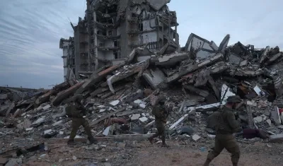 Foto de archivo de unos soldados israelíes caminando entre los escombros de edificios destruidos en la localidad palestina de Beit Lahia