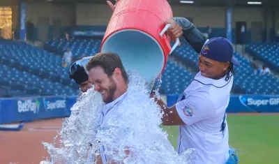 Luke Brown es bañado por su compañero de equipo Félix Reyes.