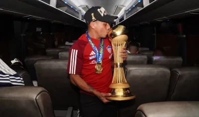 Vladimir Hernández con el trofeo de campeón en el avión que trajo al Junior de regreso a Barranquilla. 