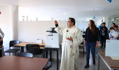 Un sacerdote rocía agua bendita en el despacho del nuevo alcalde de Tunja.