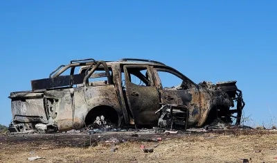 Un vehículo incinerado en medio de un ataque armado. 