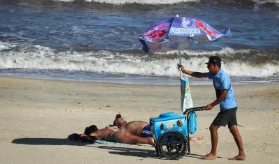 Un hombre vende helados en la Playa Pocitos de Montevideo durante una ola de calor.