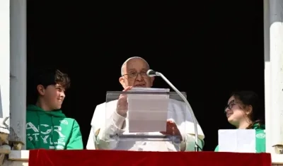 El Papa Francisco asomado desde el balcón junto a dos jóvenes de Acción Católica