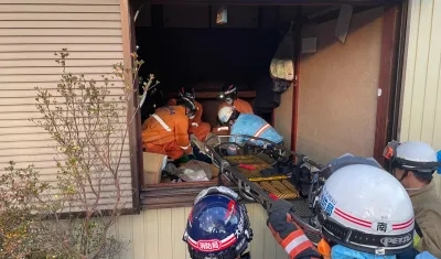 Rescatistas sacan a la anciana de la vivienda.