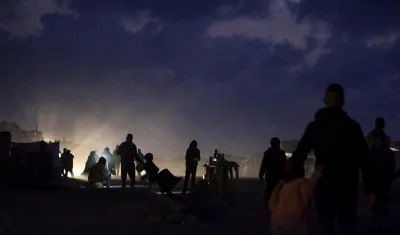 Palestinos que huyeron con sus familias del norte de la Franja de Gaza caminan por la zona de refugios. 