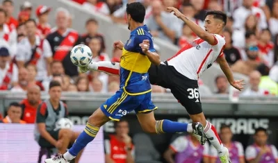 Pablo Solari, de River Plate, disputa el balón con Jorge Figal, de Boca.