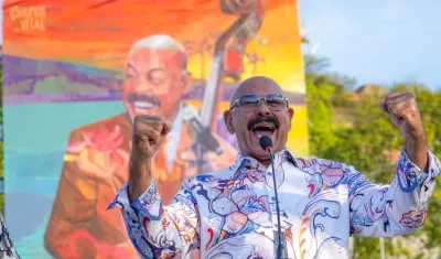 Óscar D' León y al fondo el gigantesco mural develado en su honor. 