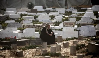 Una palestina visitando la tumba de un ser querido.