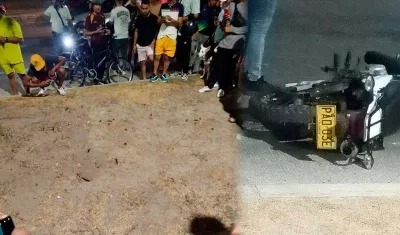 Curiosos en el sector donde cayó la persona acribillada y la moto en la que se desplazaba