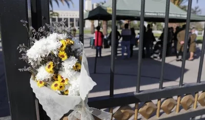 Personas llegan a firmar un libro de condolencias, en la Escuela de Carabineros, este sábado en Santiago, tras el asesinato de tres policías 