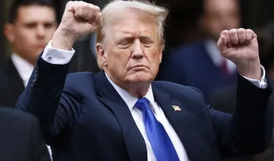 Donald Trump hace gestos a los medios de comunicación y a la multitud afuera de la Torre Trump. 