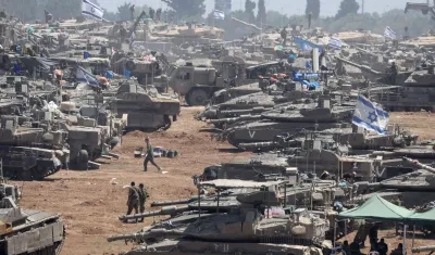 Soldados israelíes junto a sus vehículos militares se reúnen en Gaza.