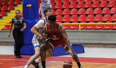 El panameño Amílcar Sánchez, de Titanes, protege la pelota ante la presión de un rival.