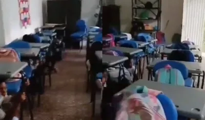 Los niños se resguardan debajo de sus pupitres. 