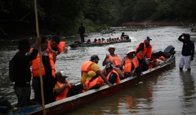 Migrantes llegan en canoas a una estación de recepción migratoria luego de cruzar la selva del Darién, en Lajas Blancas, Panamá