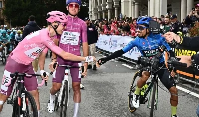 Tadej Pogacar se saluda con el colombiano Daniel Martínez antes de arrancar la tercera etapa. 