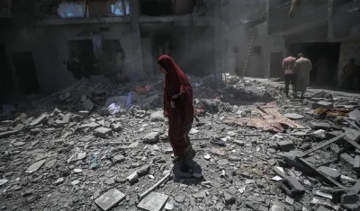 Palestinos inspeccionan los daños tras un ataque aéreo israelí en el campo de refugiados de Al Bureij, en el sur de la Franja de Gaza