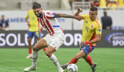 El colombiano Rafael Santos Borré disputa la pelota con Omar Alderete. 