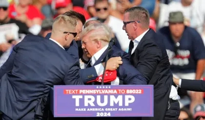 Momento en que Donald Trump es retirado por sus escoltas. 