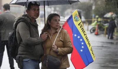 Venezolanos bajo la lluvia en Bogotá. 