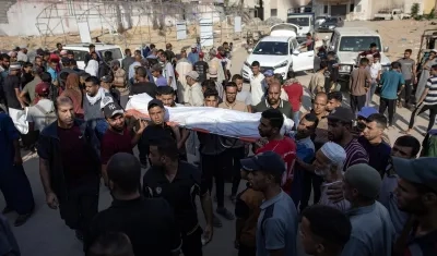 Palestinos levantan el cadáver de uno de los fallecidos.