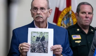 El funcionario Ric Bradshaw muestra una foto de los elementos que se encontraron junto a la valla del campo de golf