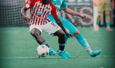 Yimmi Chará protege la pelota ante la marca de Enrique Serje.