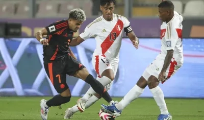 Luis Díaz intenta avanzar ante la marca de dos jugadores peruanos. 