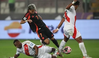 Luis Díaz es trabado por Luis Advíncula durante el partido en Lima. 
