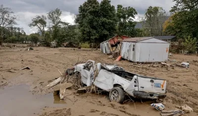 Restos de una casa móvil y un vehículo a lo largo del río Swannanoar, Carolina del Norte.