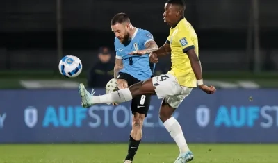 Nahitan Nández, de Uruguay, disputa un balón con Alan Minda, de Ecuador.