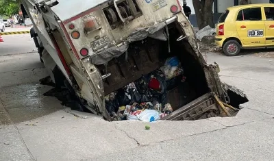 Camión de basura en gigante hueco que se abrió en el barrio Buenos Aires. 