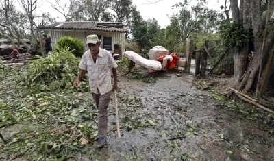 Hombre caminando entre escombros tras el paso del huracán Rafael. 