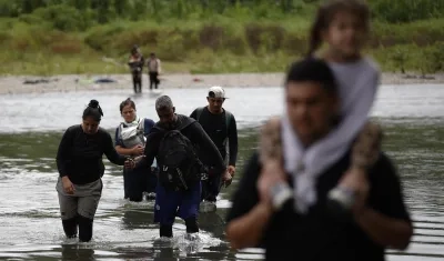Migrantes cruzando el río Tuquesa luego de atravesar la selva del Darién, en Panamá.