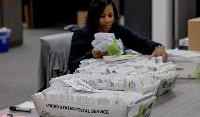 Una trabajadora del Departamento de Registro y Elecciones del Condado de Fulton clasifica los formularios de registro de votantes.