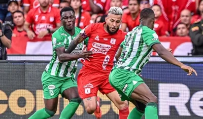 Duván Vergara busca abrirse paso entre dos jugadores de Nacional. 