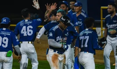 Celebración masiva de los peloteros de Vaqueros tras anotar una carrera.