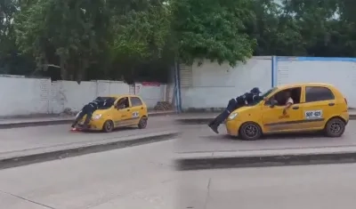 Momento en que agente está encima del capó del taxi.